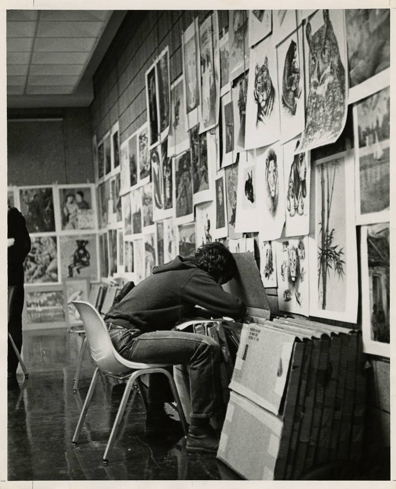 Student looking in portfolio. Photo taken between 1960 and 1969. (Image courtesy of DePaul University Special Collections and Archives)